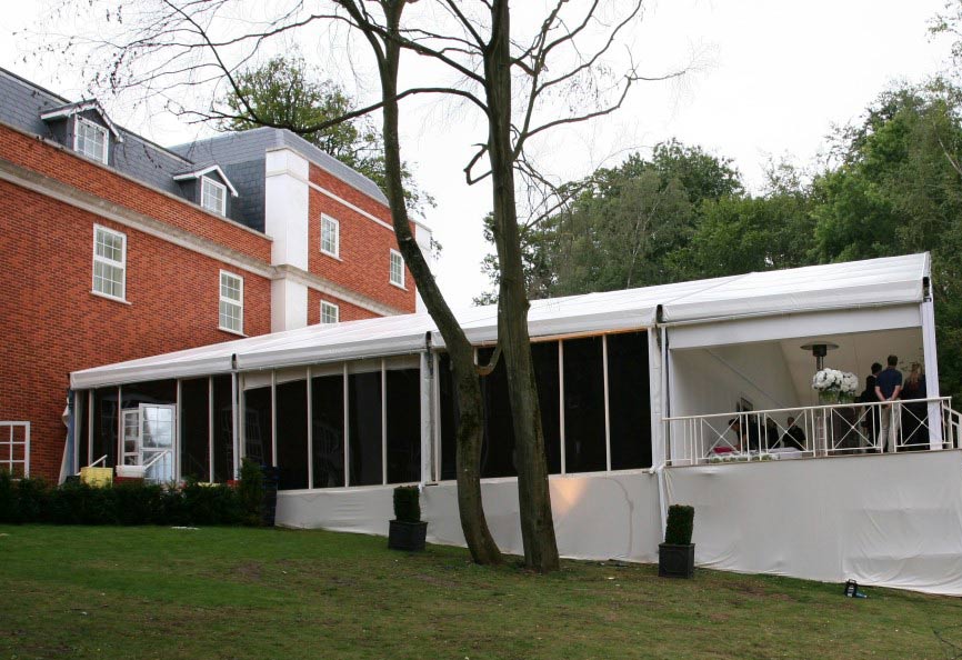 Luxury marquee structure installed alongside country house for outdoor reception