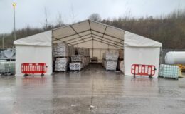 Storage marquee providing secure weatherproof storage for palletised materials at an industrial site during wet weather.