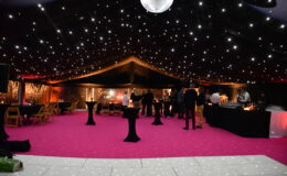 Starcloth marquee ceiling with mirror ball, pink carpet and evening event lighting setup.