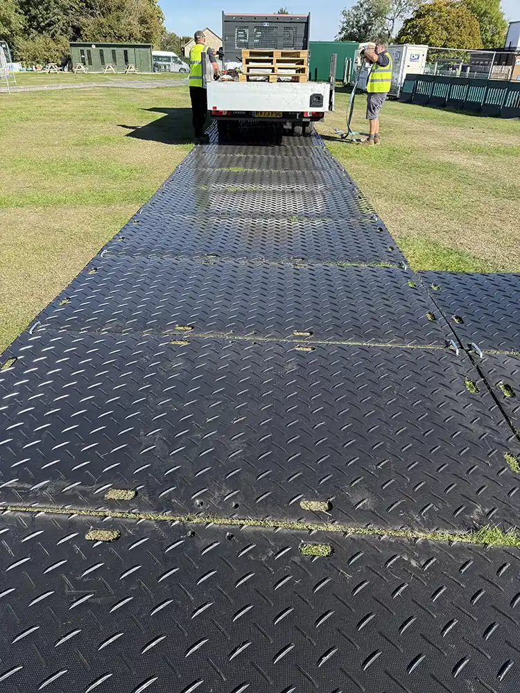 Temporary roadway trackway providing vehicle access across grass for a commercial site